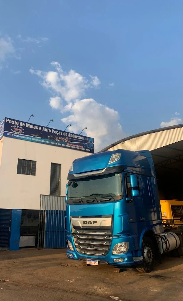 Caminhão azul em frente ao Posto de Molas e Auto Peças do Anderson